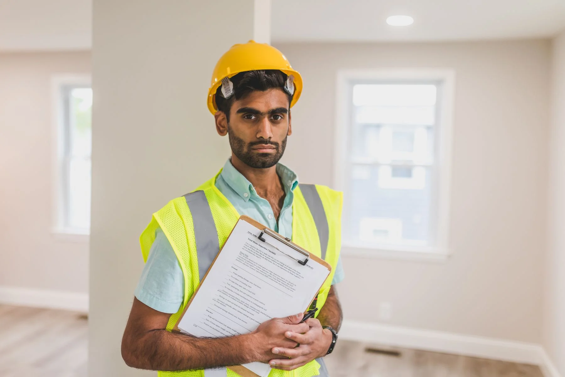 Site inspector holding a clipboard in protective equipment