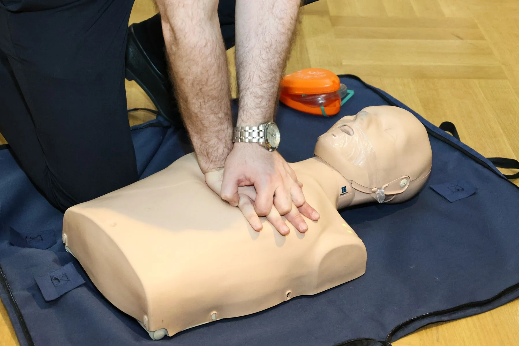 Hands practising CPR on a training mannequin — illustrative photograph