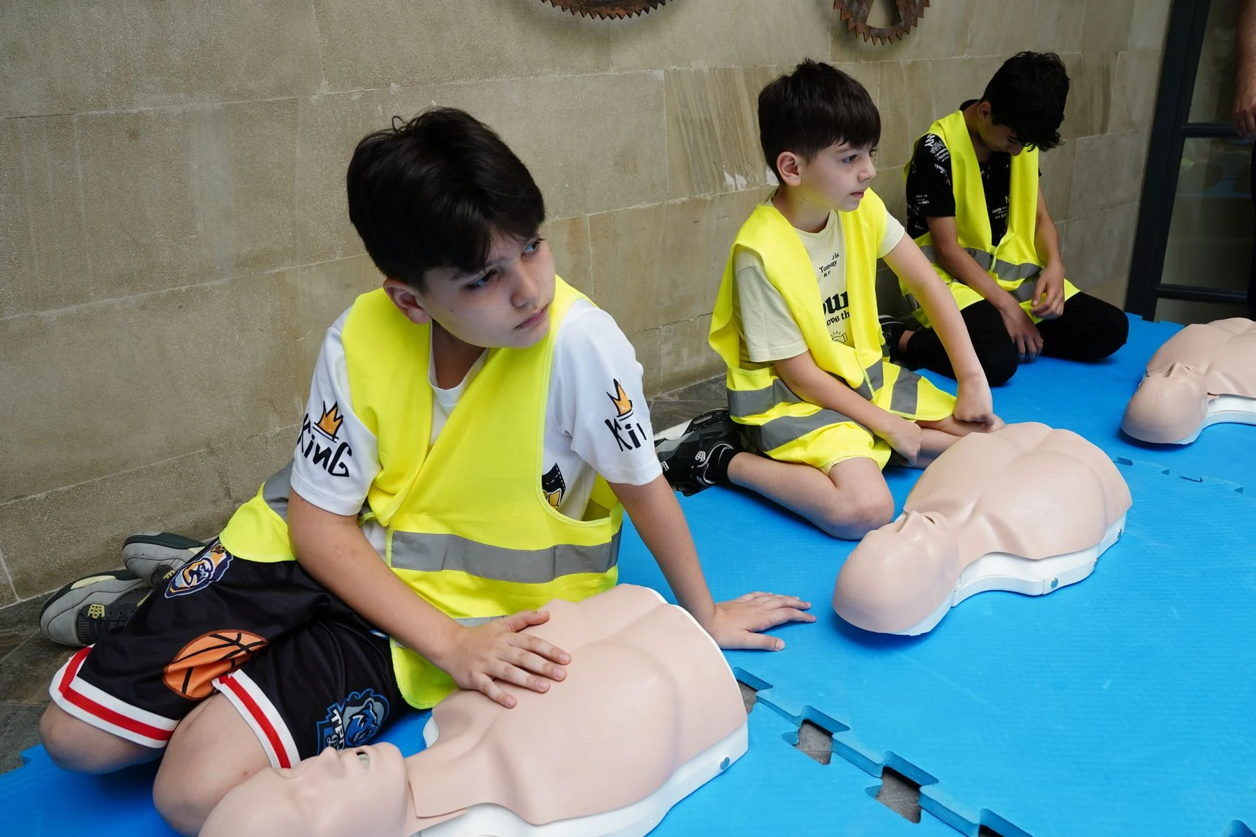Children practising CPR on training mannequins