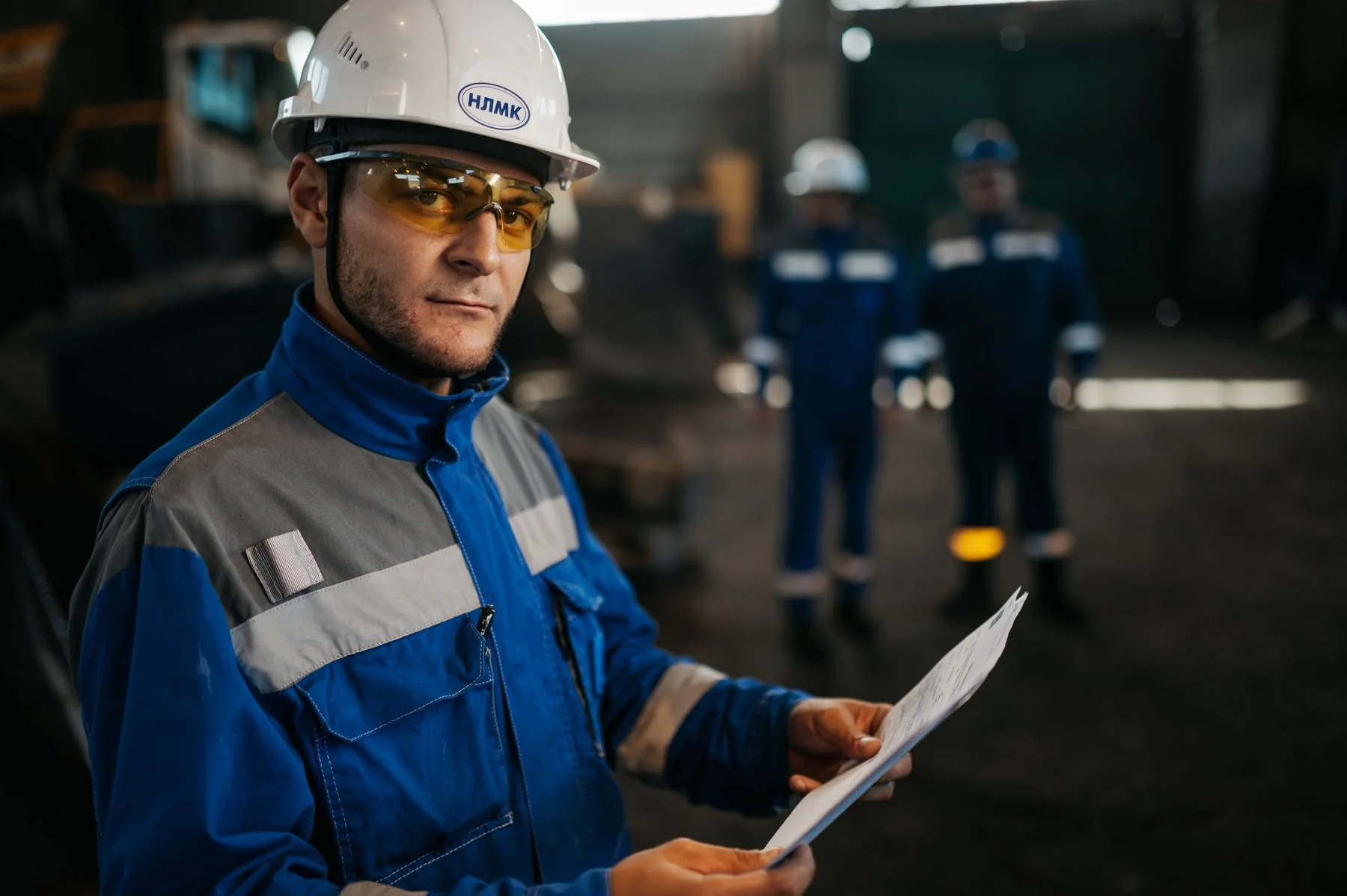 Industrial worker reviewing documents in a factory — illustrative photograph