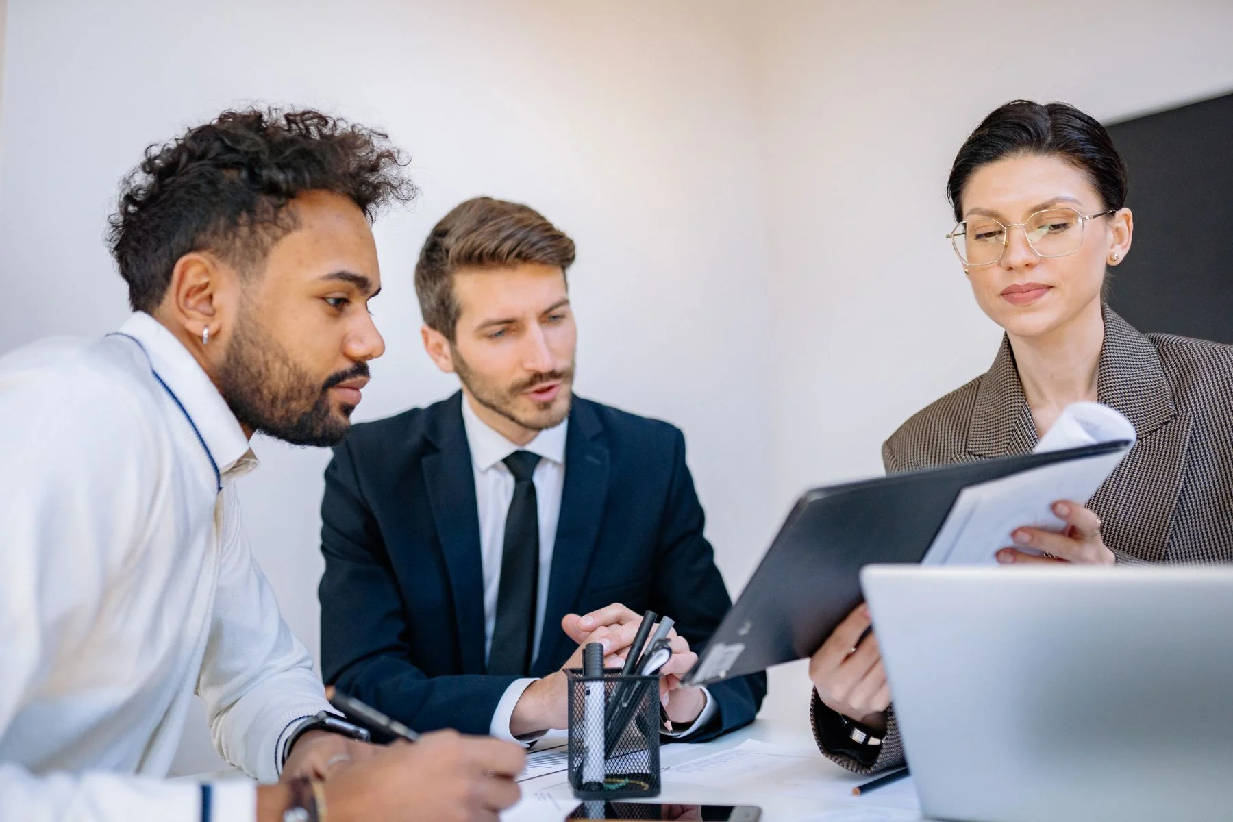 Colleagues discussing a document during a meeting — illustrative photograph