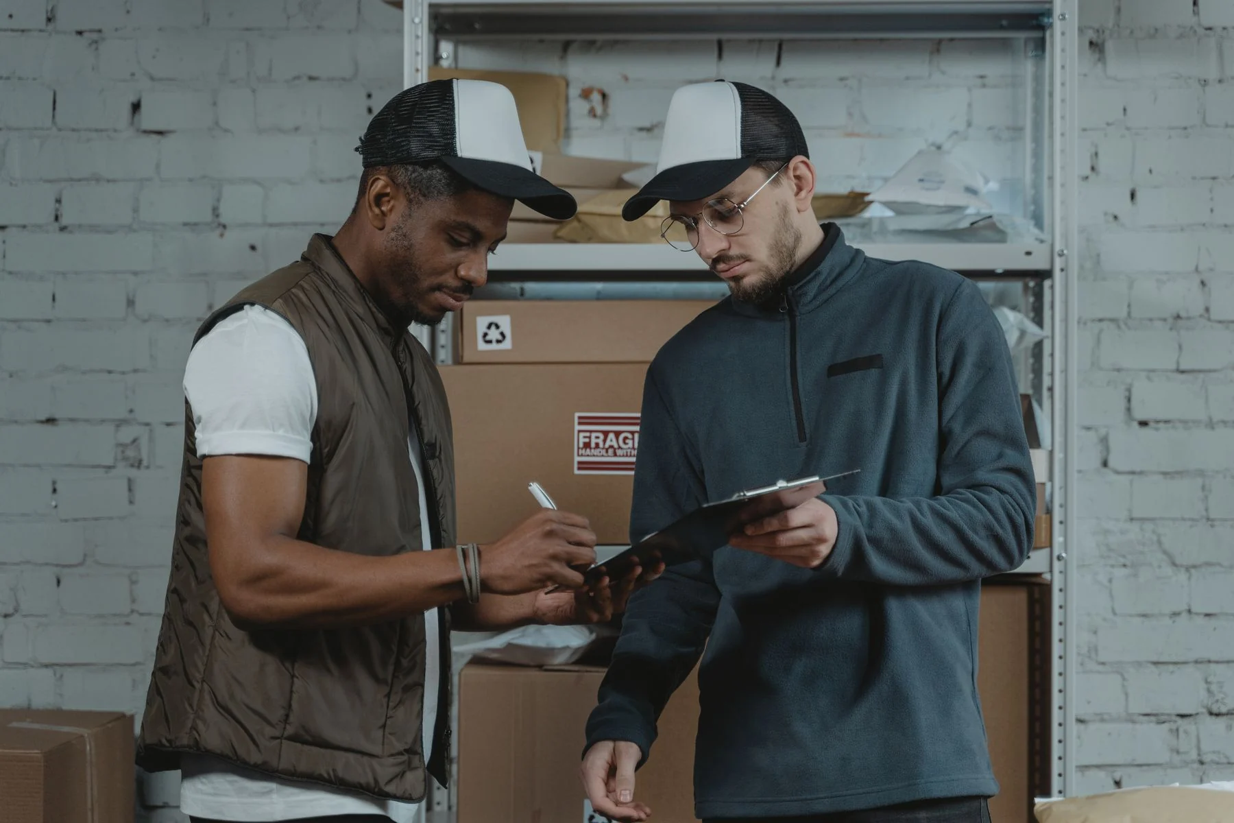 Warehouse colleagues checking and signing workplace documents