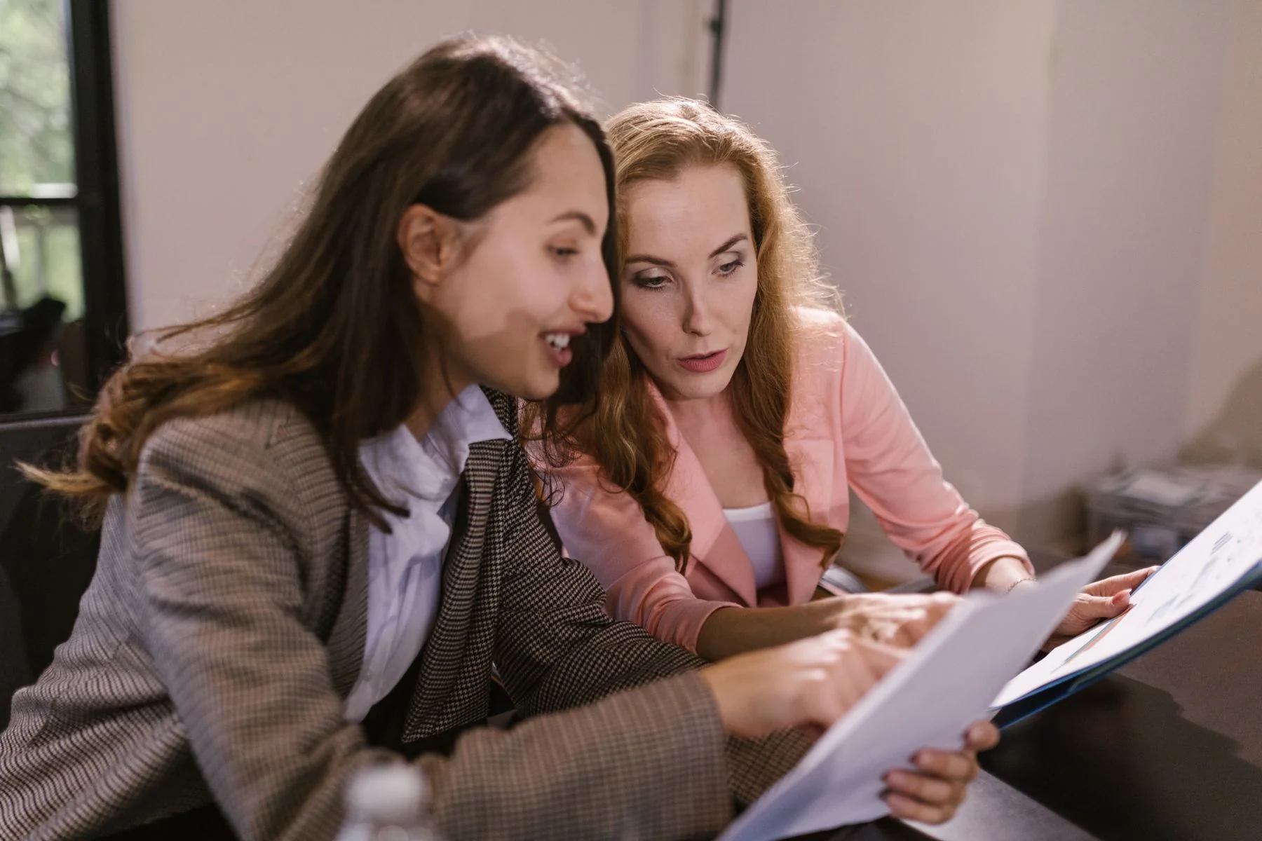 Colleagues reviewing paperwork together — illustrative photograph