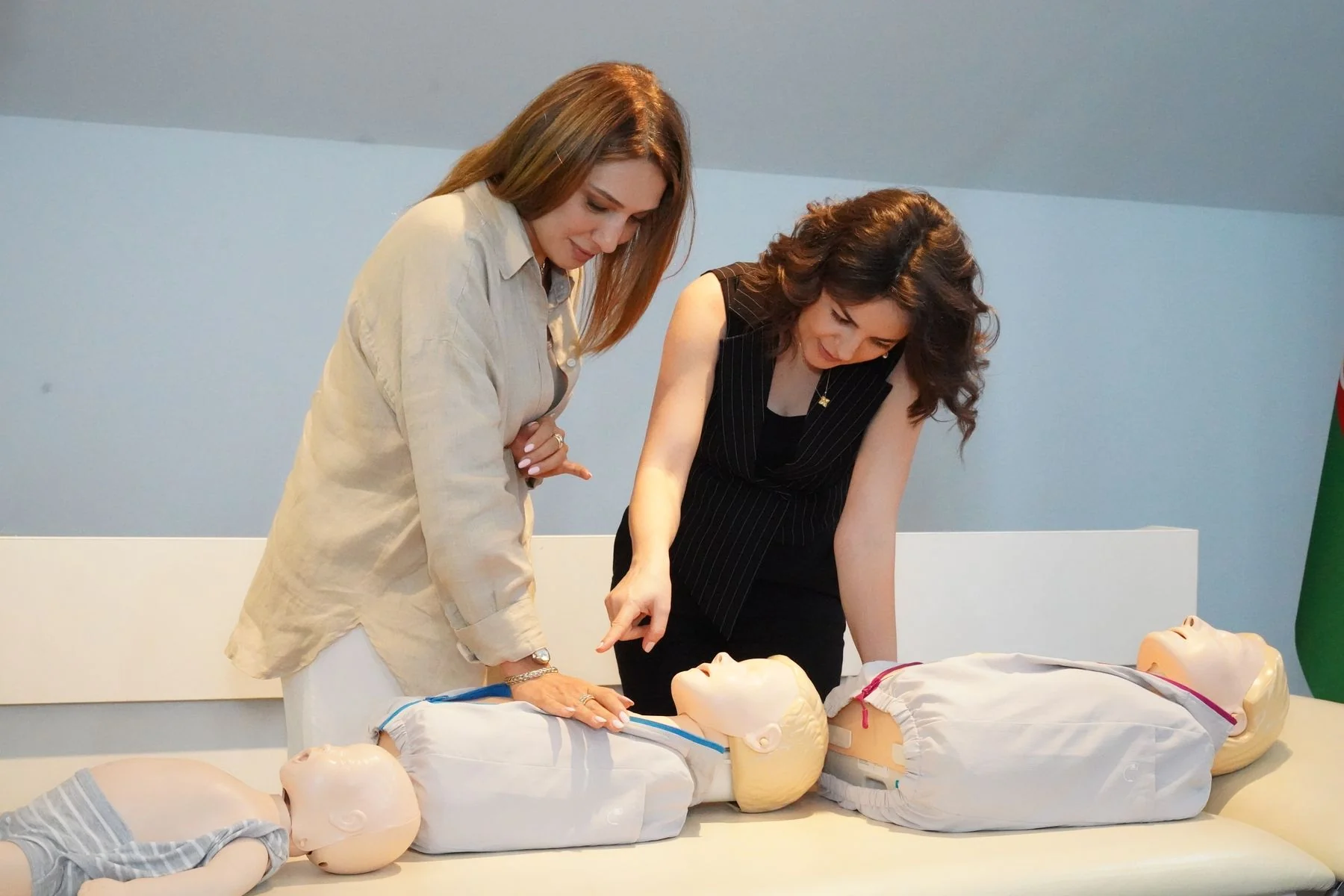 Two women practising CPR on training mannequins